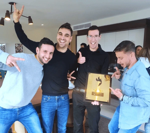El equipo de Agencia Riders celebrando con una placa de reconocimiento